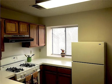 Kitchen featuring visible vents, white appliances