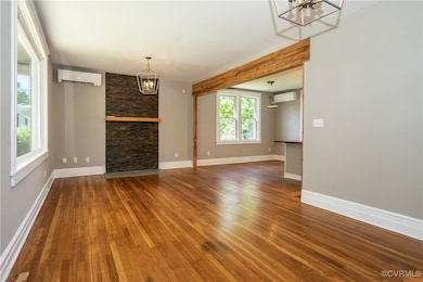 Living room featuring a chandelier, a wall unit AC