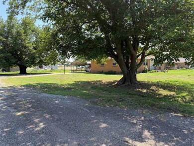 View of grassy yard featuring a detached carport