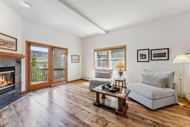 Living area featuring a tiled fireplace, wood floo