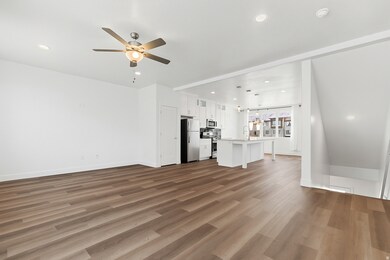 Unfurnished living room featuring dark wood-style floors, recessed lighting, a chandelier, and ceiling fan