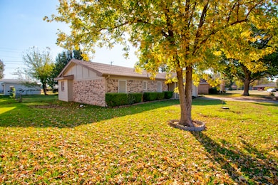 View of home's exterior with brick siding, a lawn, and board and batten siding