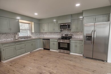 Kitchen featuring backsplash, sink, light hardwood