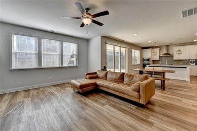 Living area with a ceiling fan, baseboards, light 