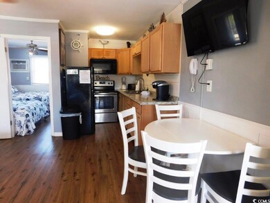 Kitchen featuring black appliances, light countertops, dark wood-type flooring, a ceiling fan, and crown molding