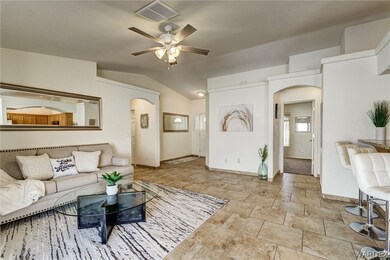 Tiled living room with ceiling fan and lofted ceil