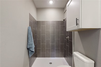 Bathroom with toilet and a tile shower