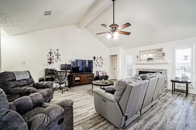 Spacious family room featuring a beautifully crafted fireplace with elegant brick accents.