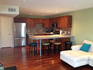 Kitchen with dark wood finished floors, a peninsu