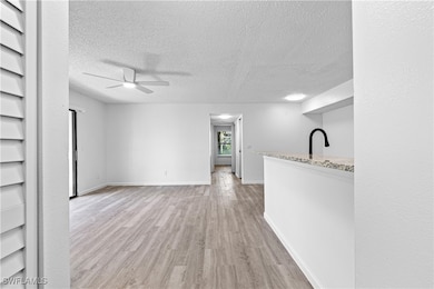 Unfurnished living room featuring ceiling fan, a t