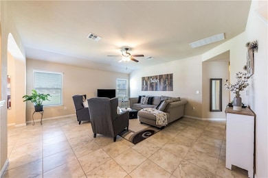 Living area featuring ceiling fan and light tile 