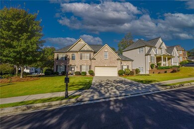 View of front of property featuring driveway, a front lawn, a garage, and brick siding
