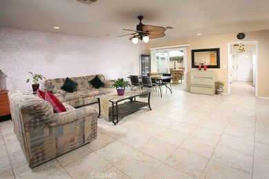 The large living room has beautiful tile flooring, recessed lighting, tropical lighted ceiling fan, plus direct patio access.