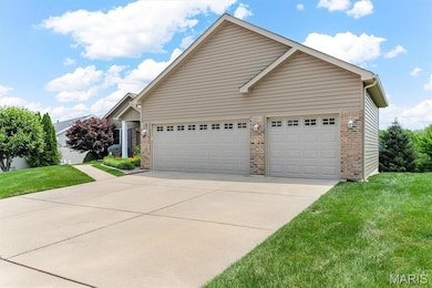View of front facade featuring brick siding, driveway, a front yard, and an attached garage