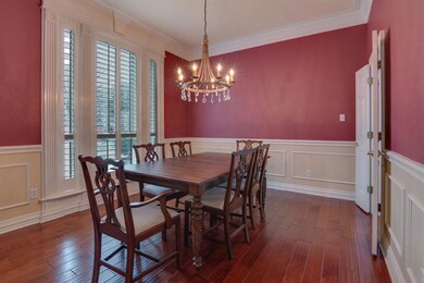 Elegant Mouldings, Plantation Shutters and a Chandelier Define the Formal Dining Room.