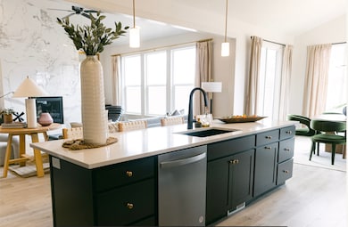 Kitchen featuring dishwasher, hanging light fixtures, light wood finished floors, green cabinetry, and vaulted ceiling
