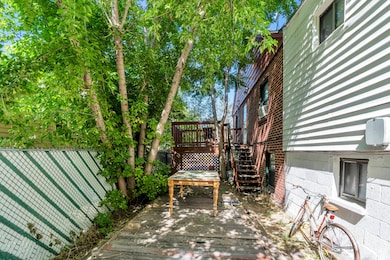 Fenced backyard featuring a wooden deck and stairway