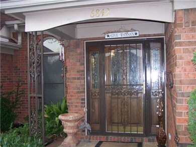 Covered porch and inviting doorway of this all bri