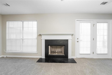 Detailed view of carpet flooring and a fireplace with flush hearth