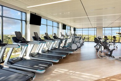 Gym with wood finished floors and expansive windo