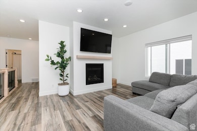 Living room featuring recessed lighting, baseboards, light wood-style floors, visible vents, and a fireplace