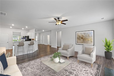 Living room with visible vents, recessed lighting,