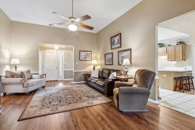 Living area with crown molding, a ceiling fan, and