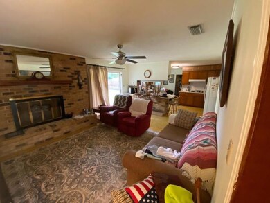 Living room featuring a brick fireplace, visible v