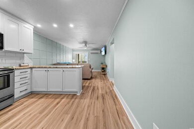 Kitchen featuring white cabinets, ceiling fan, ran