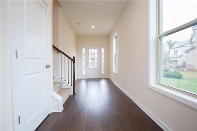 Foyer with dark wood-style floors, stairs, and recessed lighting