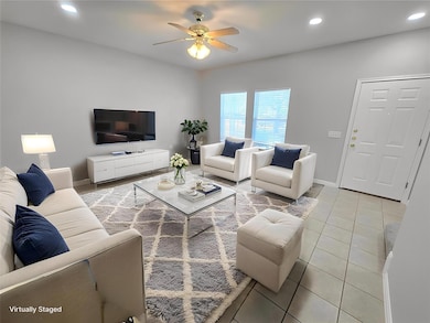 Living area featuring recessed lighting, light tile patterned floors, and ceiling fan