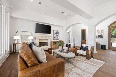 Living area with arched walkways, a fireplace, cr