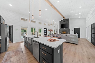 Kitchen featuring beam ceiling, decorative light f