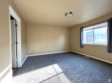 Empty room with carpet and baseboards