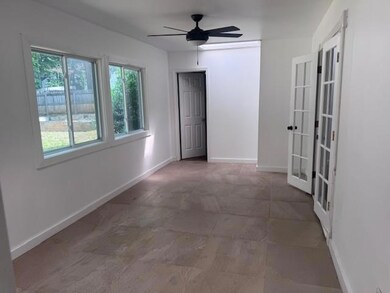 Empty room featuring french doors, ceiling fan, and baseboards