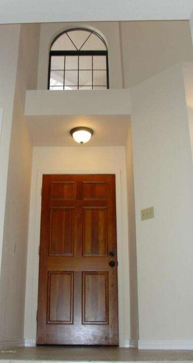 Foyer Features High Ceiling & Wood Door