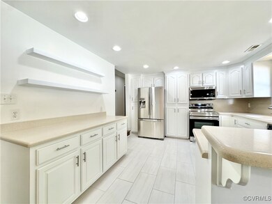 Kitchen with white cabinets and appliances with st
