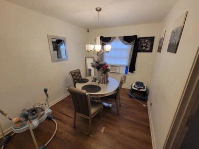 Dining room with dark wood finished floors and a chandelier