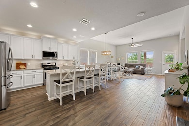 Kitchen featuring dark wood-type flooring, visibl