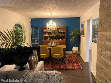 Dining space with a chandelier, beautiful large circular window facing the front - shown furnished