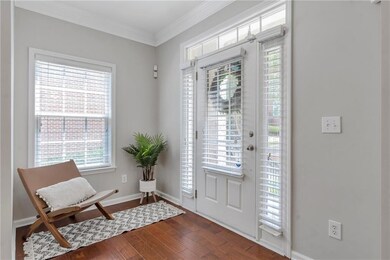 Entryway with crown molding, plenty of natural light, and dark wood-style flooring