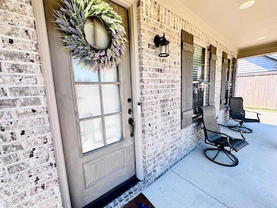 Property entrance featuring brick siding and covered porch