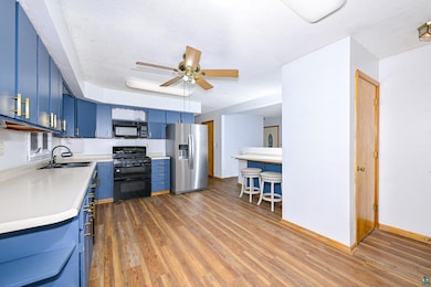 Kitchen featuring black appliances, blue cabinets,