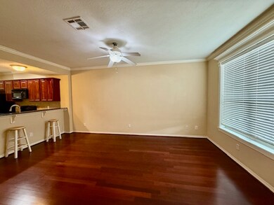 Unfurnished living room with dark wood finished floors, ornamental molding, ceiling fan, and a textured ceiling