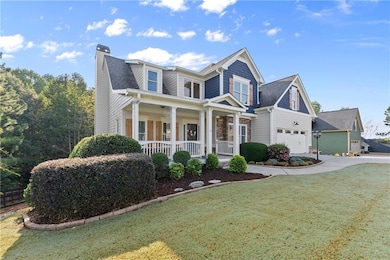 View of front facade featuring a porch, a front yard, a garage, a chimney, and concrete driveway