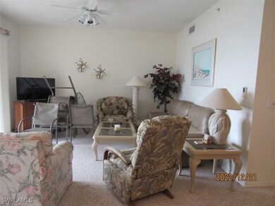 Carpeted living area with ceiling fan