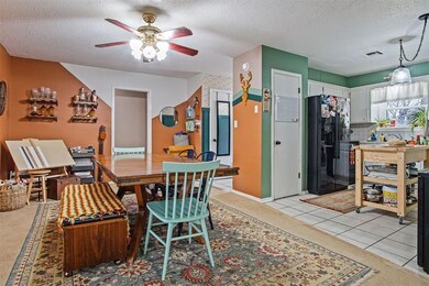 Tiled dining space with ceiling fan and a textured