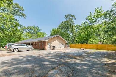 View of side of home with brick siding, fence, and driveway