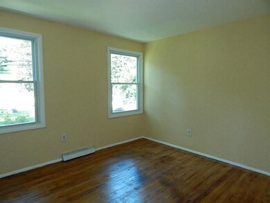 Bedroom. Neutral walls, gleaming hardwood floors.