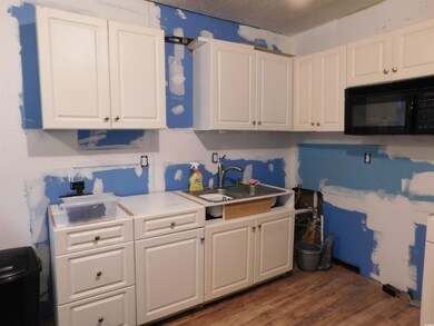 unfinished Kitchen with sink, and white cabinets